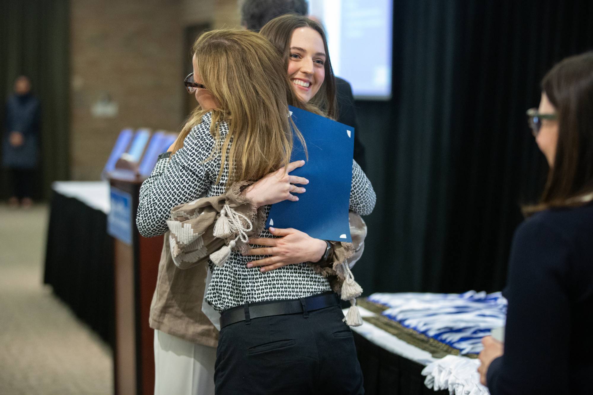 Professor Ellen Adams gives graduating&#160;student a hug.